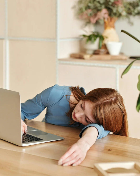 tired at a desk with a laptop on the work desk
