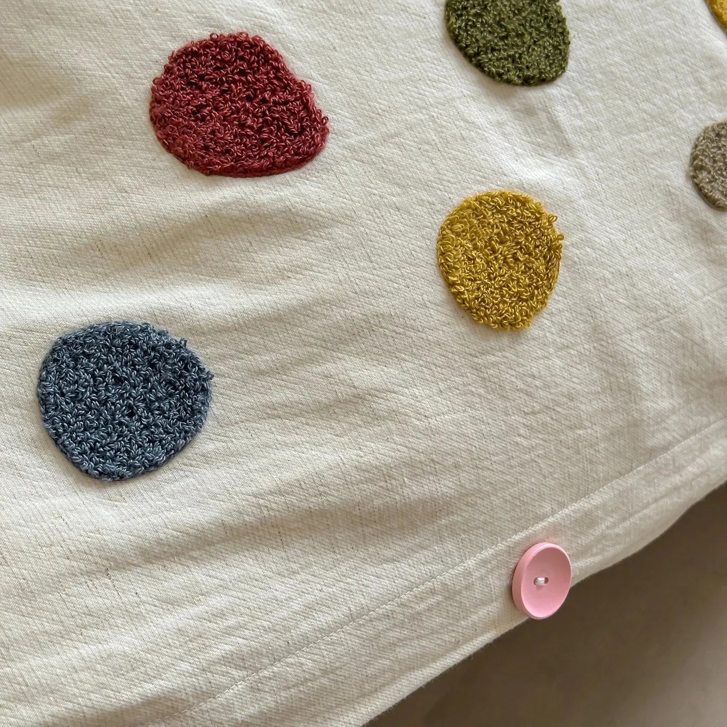 Textured multicolor polka dot duvet cover with pink button on cream cotton fabric