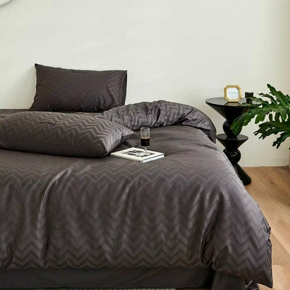 600TC Egyptian Cotton Diamond Wave Pattern Duvet Set in black with a wine glass on a book at the foot of the bed - Fluffyslip