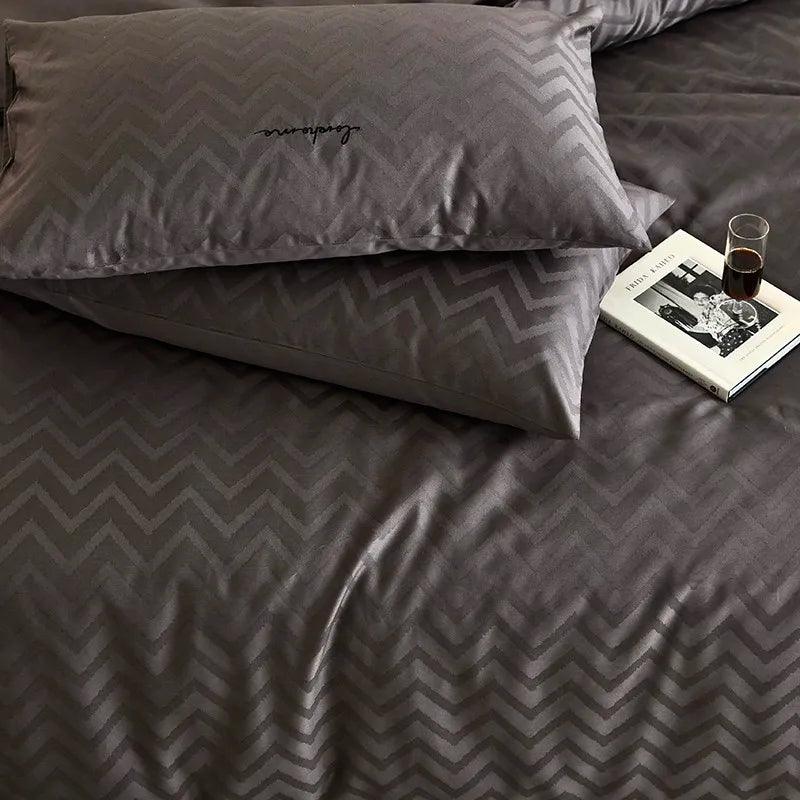 close up of 600TC Egyptian Cotton Diamond Wave Pattern Duvet Set with a wine glass on top of a book next to two pillows - Fluffyslip