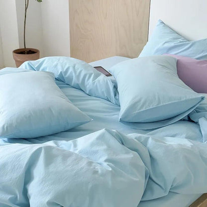 Vibrant Washed Cotton Color Duvet Cover Set in baby blue in a minimalistic style bedroom, with an apple ipad next to the blue pillowcase- Fluffyslip